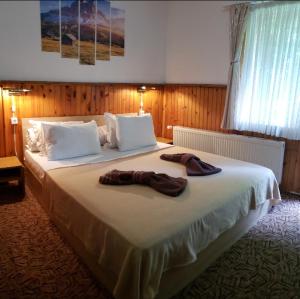 波罗维茨Guest Rooms- KLEPALSKI House的一间卧室配有一张大床,上面有两双鞋