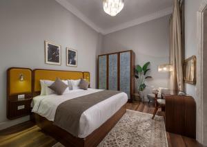开罗Lemon Spaces VINTAGE- Downtown的一间卧室配有一张大床、一张桌子和一把椅子
