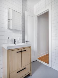 布鲁克林Modern Three Bedroom Brooklyn Condo-Hotel的一间带水槽和镜子的浴室