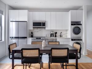 布鲁克林Modern Three Bedroom Brooklyn Condo-Hotel的厨房配有白色橱柜和桌椅