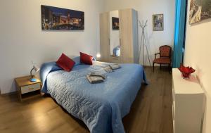 威尼斯TINTORETTO 1 CON TERRAZZA SOPRA IL TETTO, 3 bagni, 3 grandi camere da letto, SUPER NUOVO的一间卧室配有一张带蓝色床单和红色枕头的床。