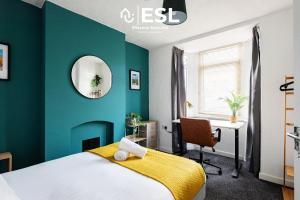 雷克瑟姆3 bedroom House - Next to Wrexham FC Racecourse Stadium的一间卧室设有绿色的墙壁、一张床和一张书桌