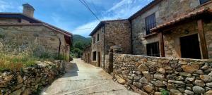 NavalguijoCasa Rural El Castaño的一条拥有石头建筑和石墙的小巷