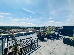 浦耳Contemporary, stylish south coast home的大楼内的阳台种植了长椅和棕榈树