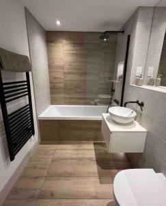 浦耳Contemporary, stylish south coast home的带浴缸、卫生间和盥洗盆的浴室