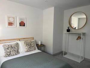 浦耳Contemporary, stylish south coast home的一间卧室配有一张床和镜子