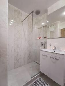 特尔古奥克纳Apartament Gold Luxury的带淋浴和盥洗盆的白色浴室