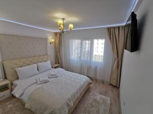 特尔古奥克纳Apartament Gold Luxury的一间卧室配有一张带白色床单的床和一扇窗户。