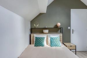 埃库昂Joli Appartement de vacances的一间卧室配有一张带蓝色枕头的大床
