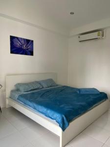 苏梅岛Infinity Bo Put Apartment的白色客房的一张床位,配有蓝色毯子
