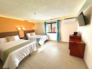 瓜纳华托Suites del Jardín Principal的酒店客房设有两张床和电视。