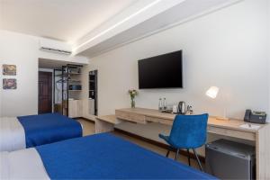 蒙巴萨Premium Inn Mombasa City的酒店客房设有一张床、一张书桌和一台电视机。