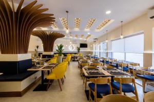 蒙巴萨Premium Inn Mombasa City的用餐室配有桌子和黄色椅子