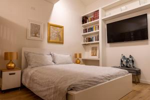 特伦托Casetta al centro的一间卧室配有一张大床和一台平面电视