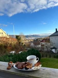 FlorvågFlorvåg -flott utsikt mot byen的桌上的一块食物和一杯咖啡
