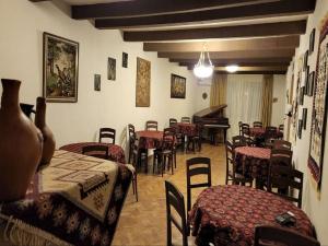 第比利斯Guest House Tbilisi style的一间带桌椅和钢琴的餐厅