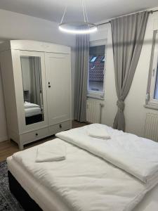 施韦青根KiMMCo Residenz am Schloss的卧室配有一张白色大床和镜子