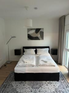施韦青根KiMMCo Residenz am Schloss的卧室内的一张带白色床单和枕头的床