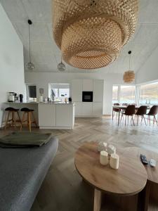 HvalvíkBrand New Waterfront-Apartment的客厅配有桌子和大吊灯