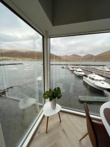 HvalvíkBrand New Waterfront-Apartment的客房设有带水中船只的大窗户。