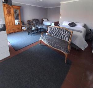 波罗瓜尼Beit-El BnB的酒店客房,配有一张床和两把椅子