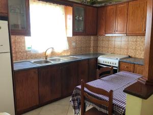 萨兰达Quality home的厨房配有木制橱柜、水槽和桌子