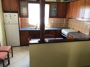 萨兰达Quality home的厨房配有木制橱柜和白色冰箱。