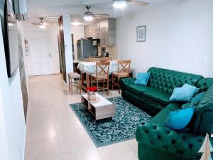 巴拿马城Punta Pacífica Oceanfront apartment的客厅配有绿色沙发和桌子