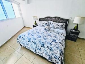 巴拿马城Punta Pacífica Oceanfront apartment的一间卧室配有一张带蓝色和白色棉被的床