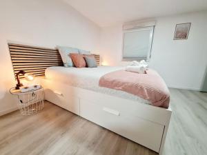 阿格诺Meublé Flora pour voyageur pro - Centre, calme - Wi-Fi的白色卧室配有一张带粉红色床单的大床