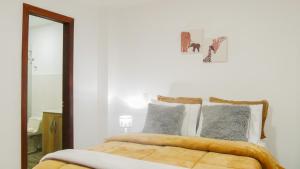 贾丁OCASSO JARDIN APARTAMENTO TURPIAL的白色卧室配有一张带镜子的床