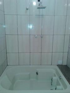 孔塔任Sítio morada nova的浴室铺有白色瓷砖,配有浴缸。
