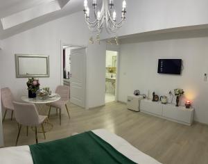 奥托佩尼Vila Zoe BucharestAirport&Therme&Parking Otopeni的白色的客房配有床、桌子和电视。