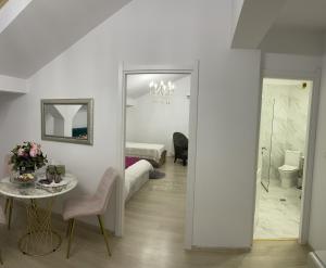 奥托佩尼Vila Zoe BucharestAirport&Therme&Parking Otopeni的白色的客房设有桌子和卧室