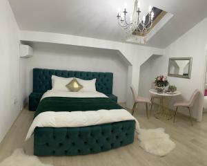 奥托佩尼Vila Zoe BucharestAirport&Therme&Parking Otopeni的一间卧室配有蓝色的床和桌椅