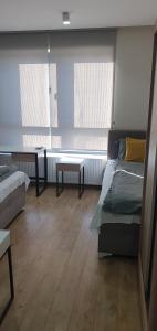 Apartmani Stara Skola的客房设有两张床、一张桌子和两个窗户。