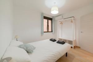格拉纳达TrendyHomes Granada - moderno apartamento a 15 minutos del centro的卧室配有白色的床和2条毛巾