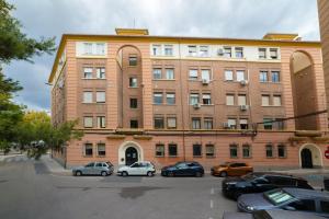 格拉纳达TrendyHomes Granada - moderno apartamento a 15 minutos del centro的一座大型砖砌建筑,停车场内有车辆停放