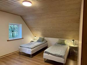 比伦德House in Billund的配有木天花板的客房内的两张床