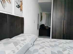 莫日-达斯克鲁济斯Apartamento Completo A25 Flat Centro的一间卧室配有一张床和一个木制橱柜