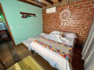 博尼图Pousada Taruma Challes 02的一间设有两张床和砖墙的房间
