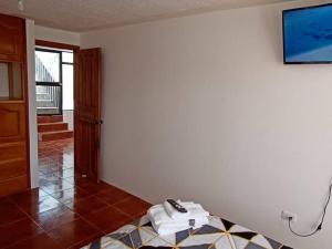 伊瓦拉Casa Amoblada y Equipada, Completamente Privada的一间墙上配有电视和一张桌子的房间