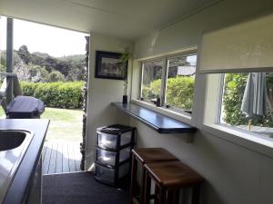 KuaotunuKuaotunu's Peebles Cottage的厨房配有水槽、两个窗户和台面