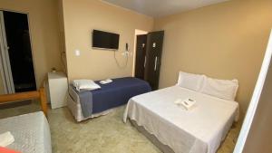 莫罗圣保罗Pousada Floripes的酒店客房设有两张床和电视。