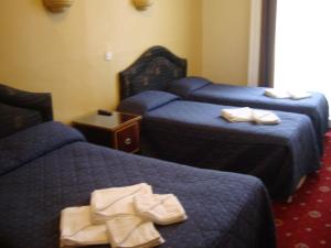 伦敦玫瑰园酒店的酒店客房,配有两张带毛巾的床