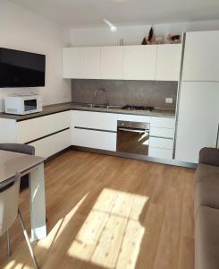 卡里索洛Appartamento con giardino的厨房配有白色橱柜、水槽和桌子
