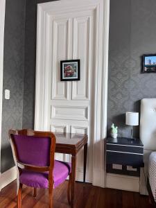 布宜诺斯艾利斯La Casa de Lola BA的配有一张桌子和一张带紫色座椅的椅子的房间