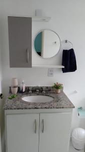 莫日-达斯克鲁济斯Apartamento Completo A25 Flat Centro的浴室的柜台设有水槽和镜子