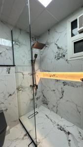 阿吉曼Luxury 2 bedroom new brand的白色大理石墙壁内的淋浴