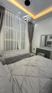 阿吉曼Luxury 2 bedroom new brand的一间卧室设有两张床和大窗户